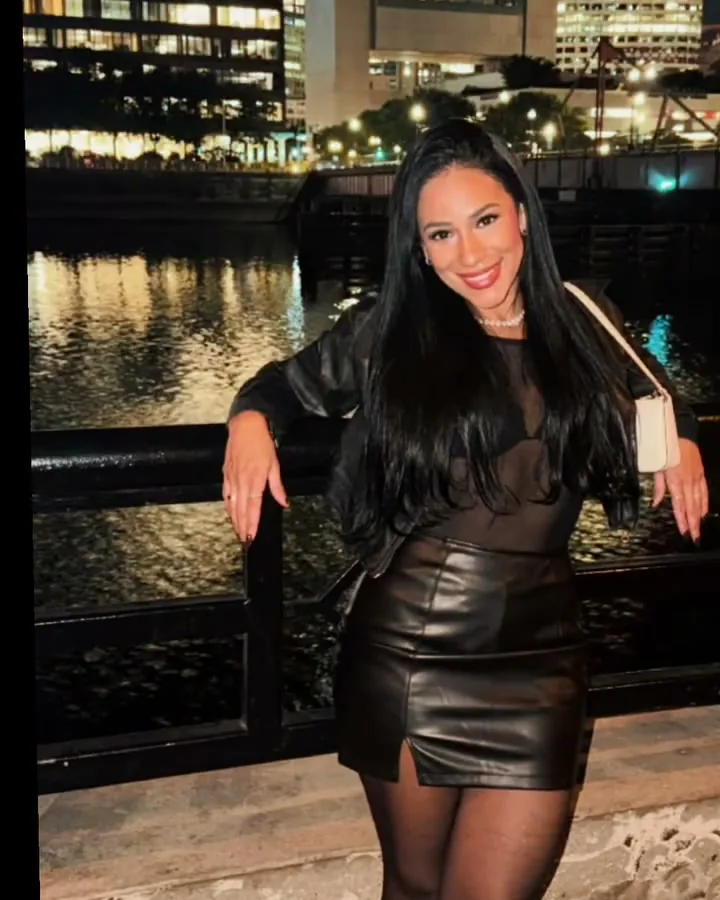 Cláudia on a night out by the water, hair down, smiling